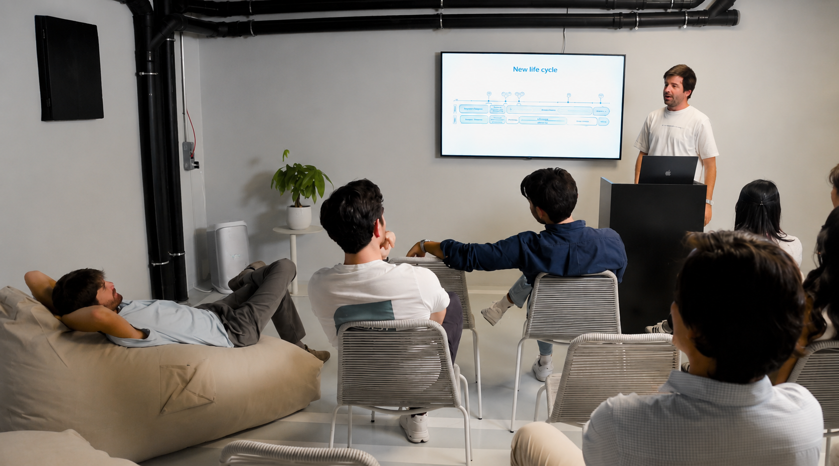 Professionals attending a presentation in a modern corporate living environment in Madrid, highlighting flexible accommodation and relocation solutions for companies.